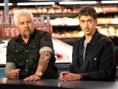 Guy Fieri and Hunter Fieri are sitting next to each other as both are looking at something.